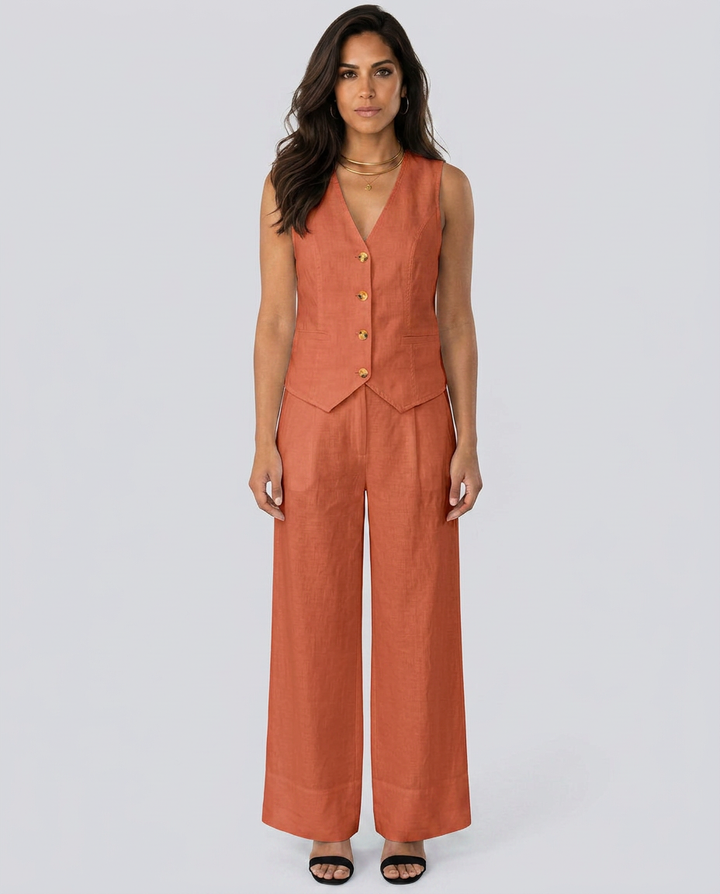 Woman wearing a rust-colored vest and wide-leg pants on a white background