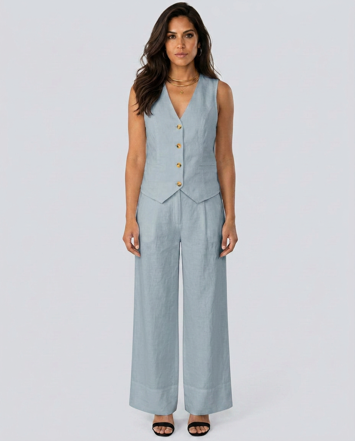 Woman wearing a light blue sleeveless jumpsuit with buttons on a white background