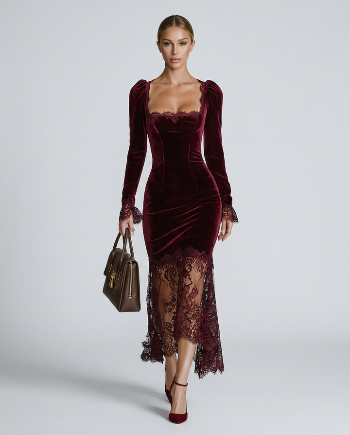 Woman wearing a burgundy velvet dress with lace detailing on a white background