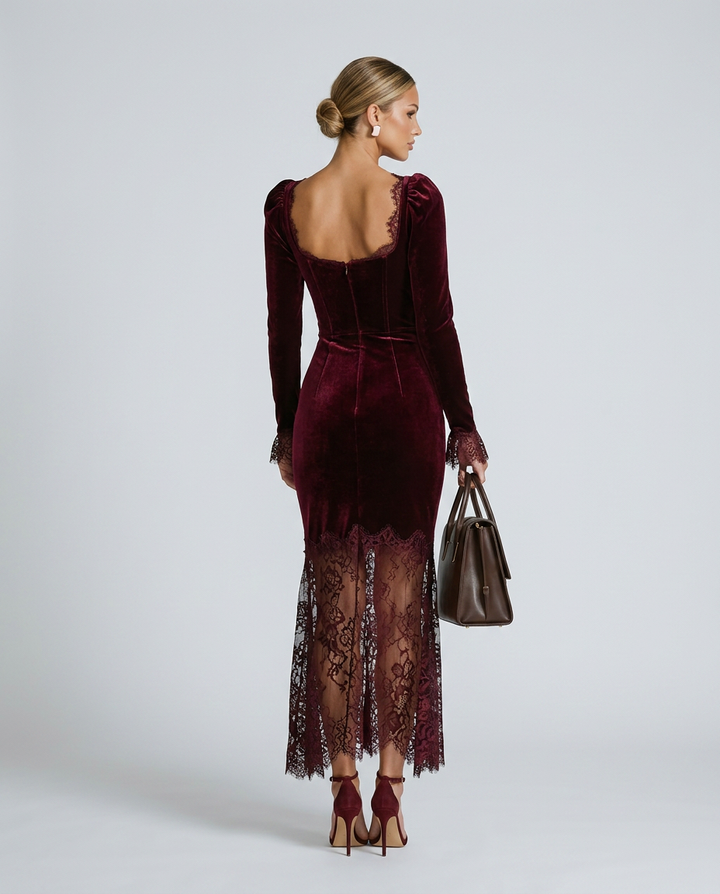 Woman wearing a burgundy velvet dress with lace details on a white background