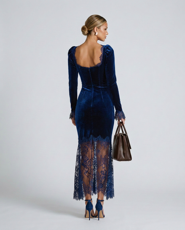 Woman wearing a blue velvet dress with lace detailing on a white background