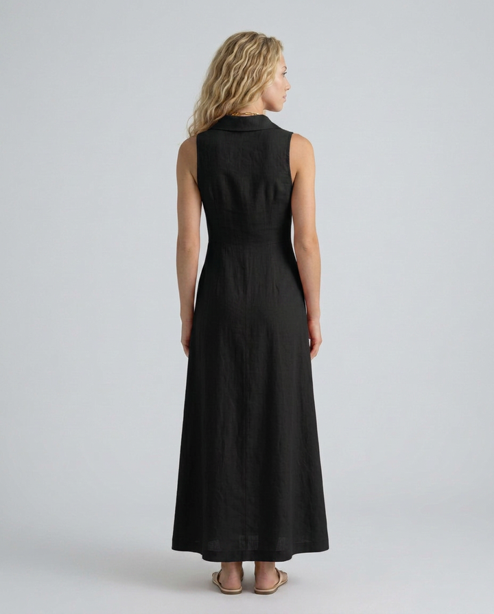 Woman wearing a black sleeveless dress on a plain background
