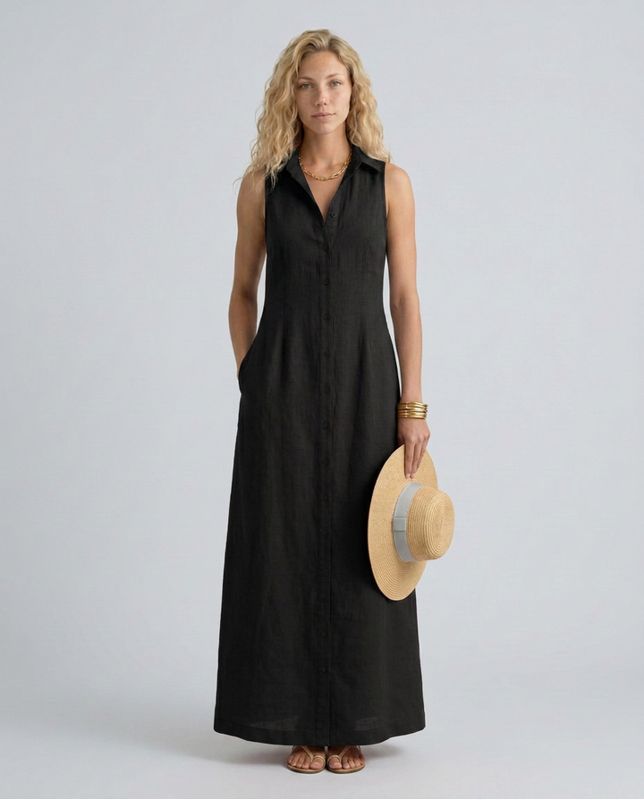 Woman wearing a black sleeveless dress holding a straw hat on a plain background