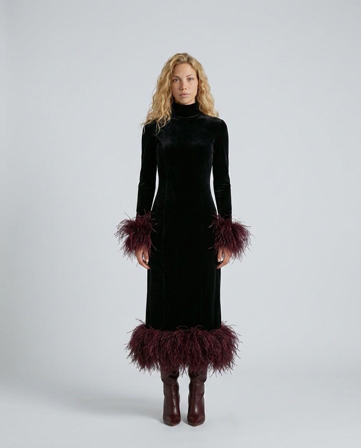 Woman wearing a black dress with feathered cuffs and hem on a white background