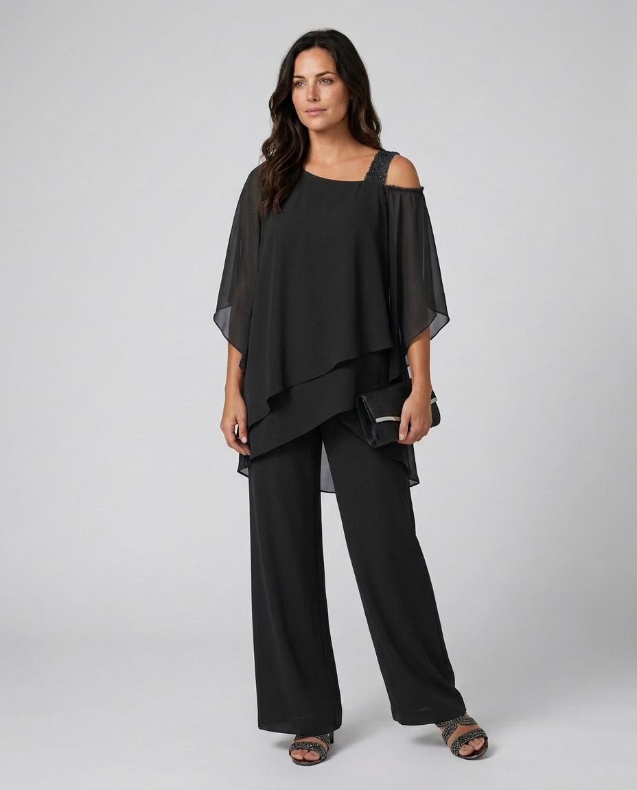 Woman wearing a black outfit with a sheer overlay on a white background