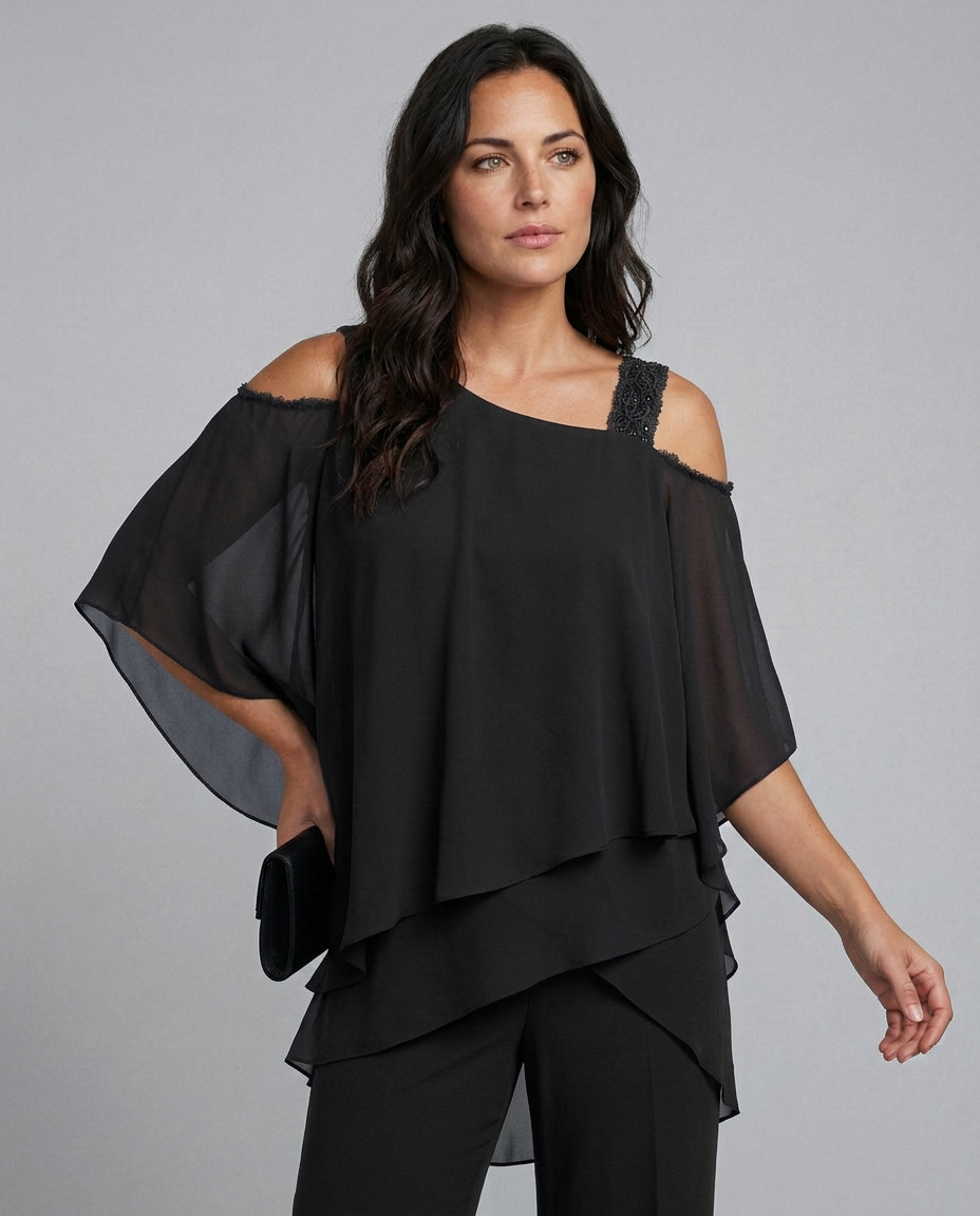 Woman wearing a black off-shoulder top with sheer sleeves on a gray background