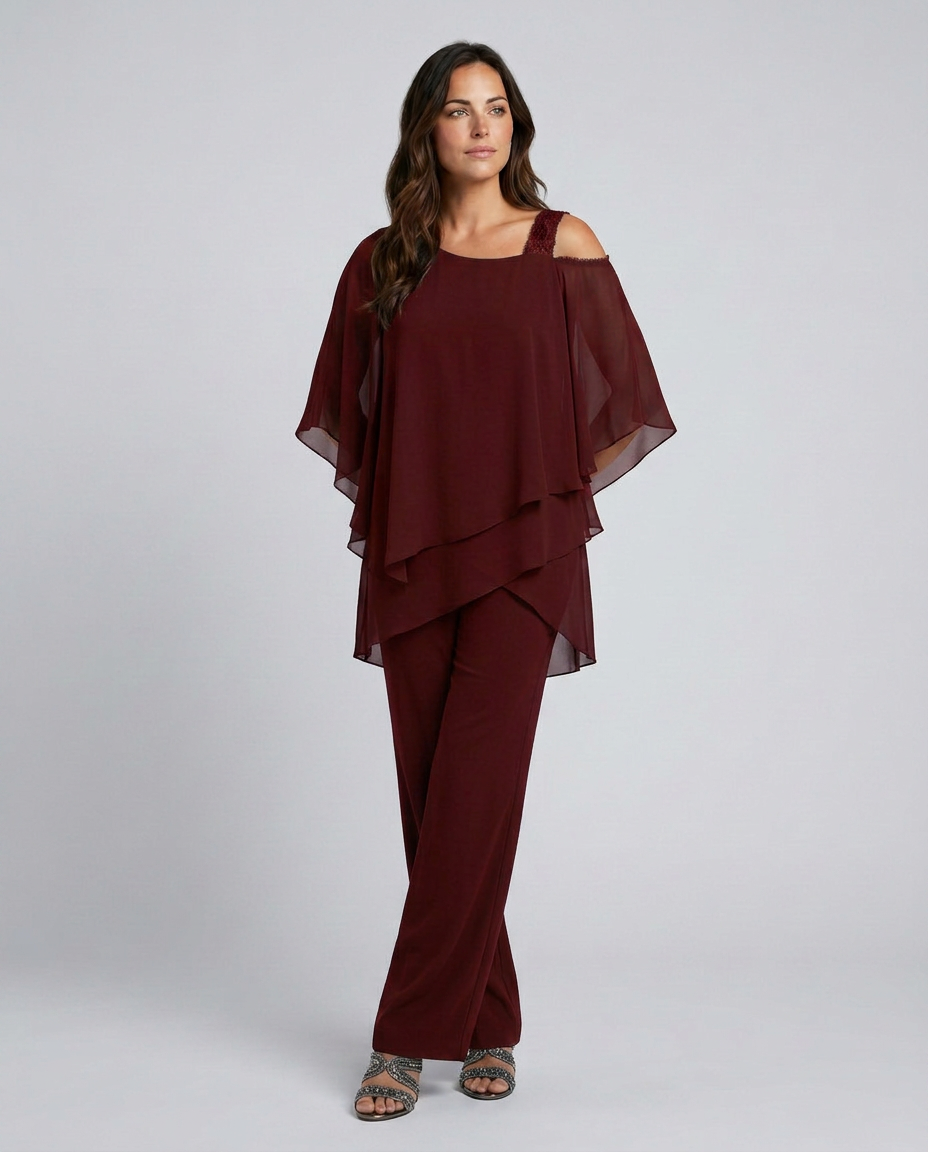 Woman wearing a burgundy outfit with a layered top and pants on a white background