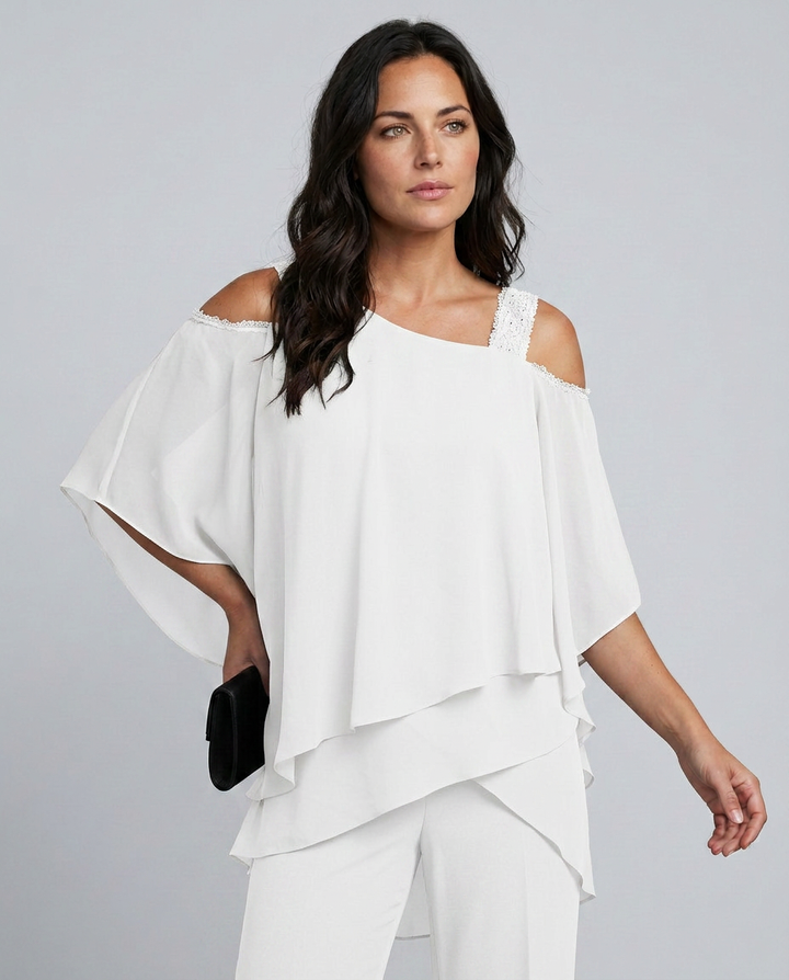 Woman wearing a white off-shoulder top and pants against a gray background