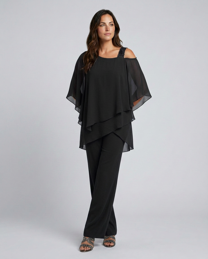 Woman wearing a black outfit with a layered top and wide-leg pants on a white background