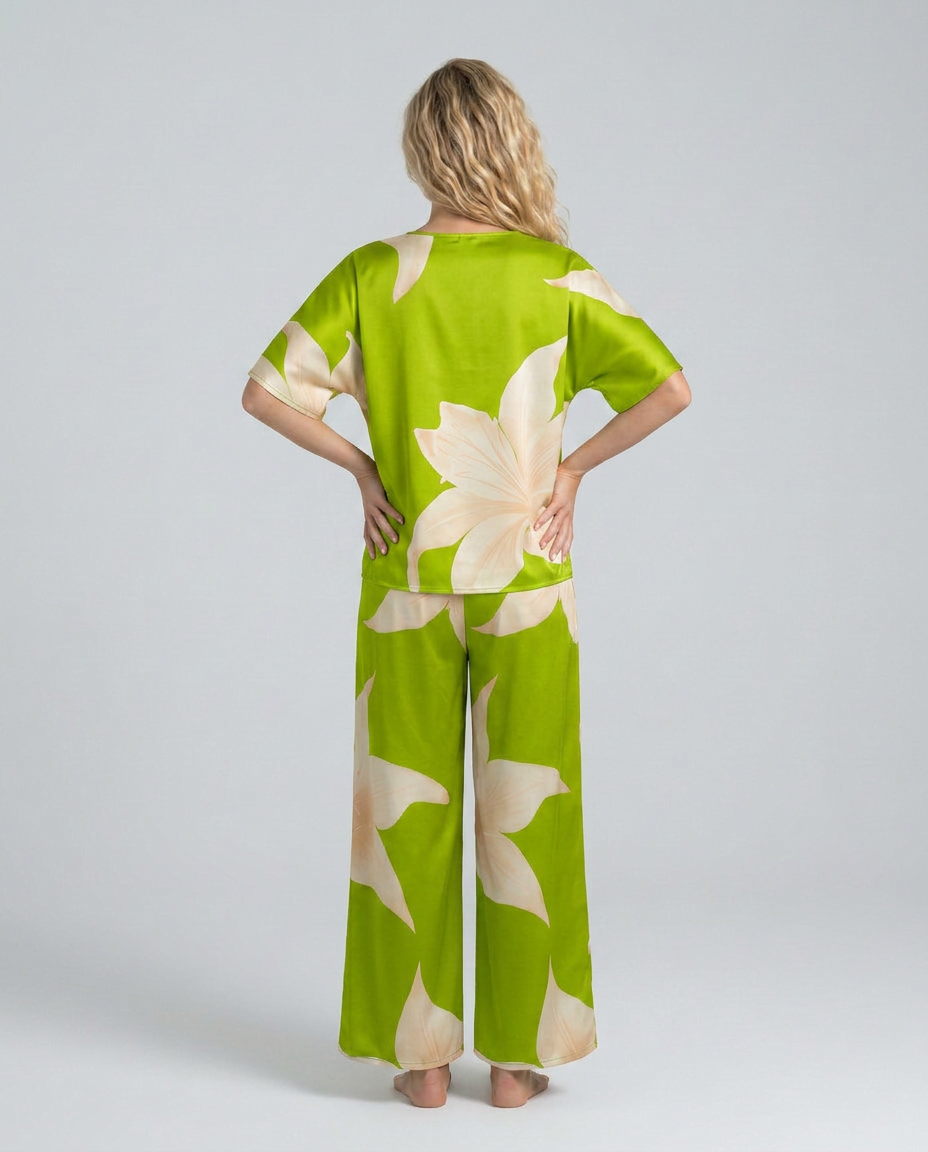 Woman wearing a green outfit with white floral patterns on a plain background