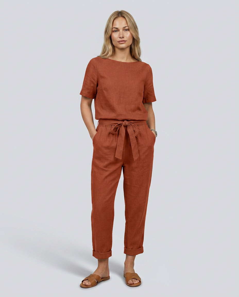 Woman wearing a brown jumpsuit on a plain background