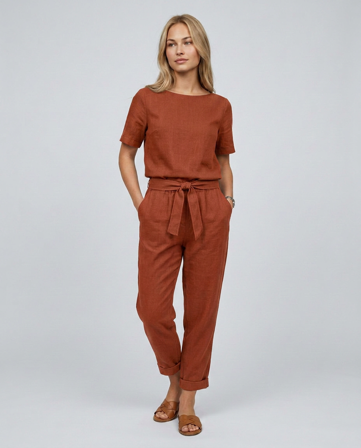 Woman wearing a brown jumpsuit on a plain background