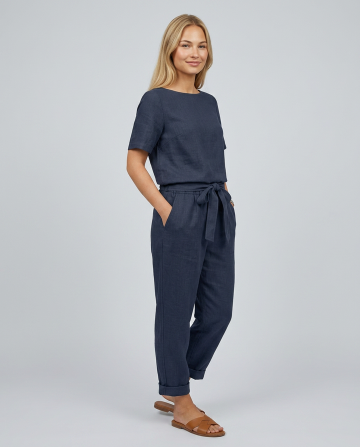 Woman wearing a navy blue outfit with a plain background