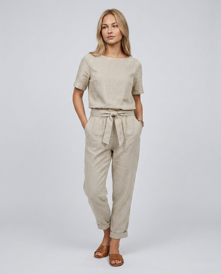 Woman wearing a beige outfit with a plain background