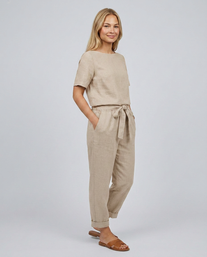 Woman wearing a beige outfit with a plain background