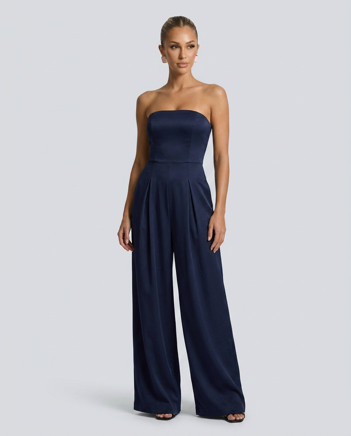 Navy strapless jumpsuit worn by a model on a light gray background