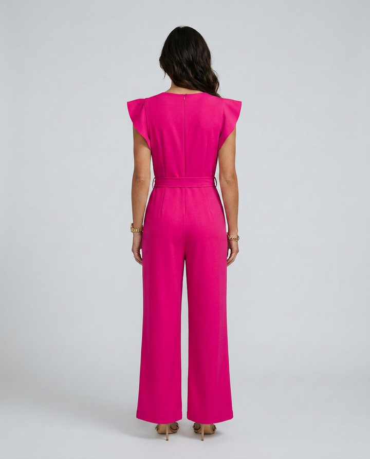 Woman wearing a bright pink jumpsuit on a white background