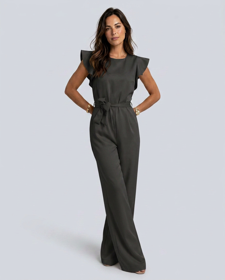Woman wearing a dark gray jumpsuit on a light gray background
