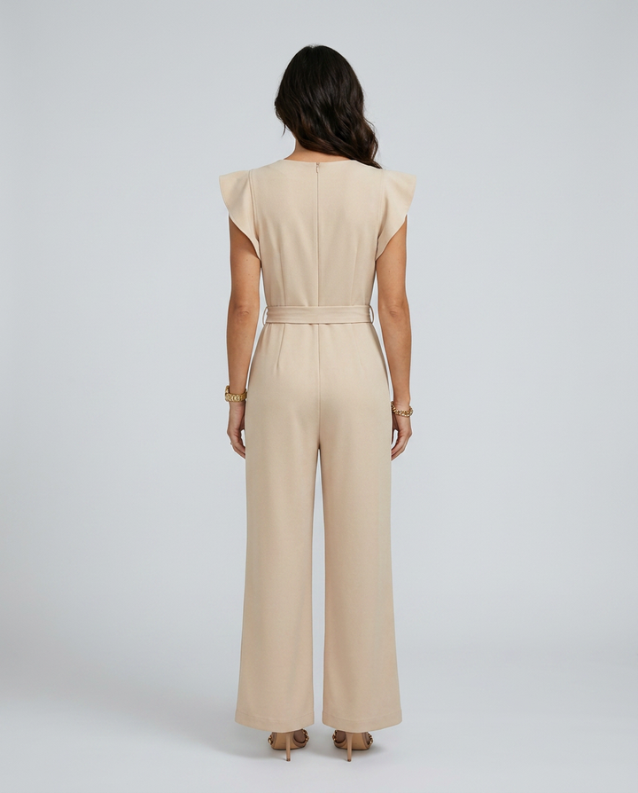 Woman wearing a beige jumpsuit on a plain background