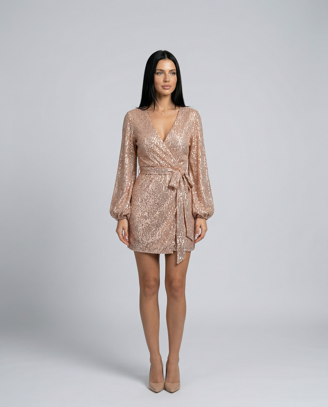 Woman wearing a sparkly gold dress on a gray background