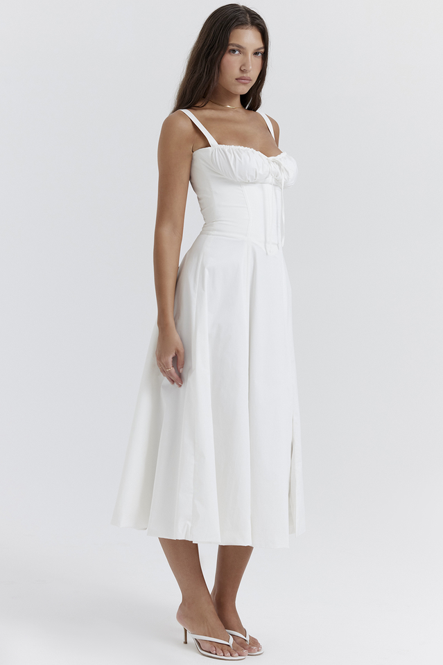 Woman wearing a white dress on a plain background