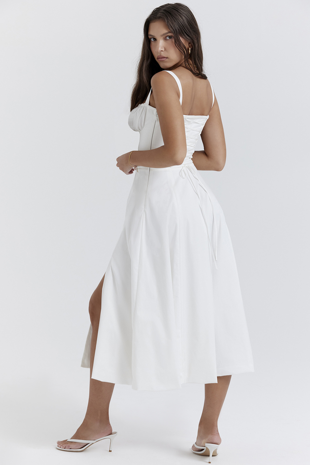 Woman wearing a white dress with a slit on a white background