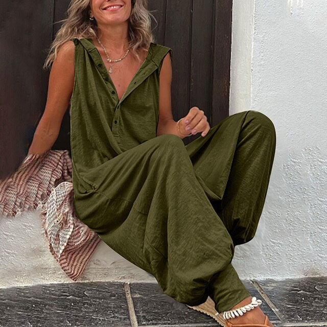 Woman wearing a green jumpsuit sitting on a step.