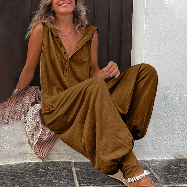 Woman wearing a brown jumpsuit sitting on a stone step.