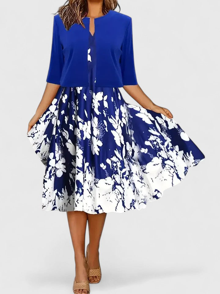 Woman wearing a blue top and floral skirt on a white background