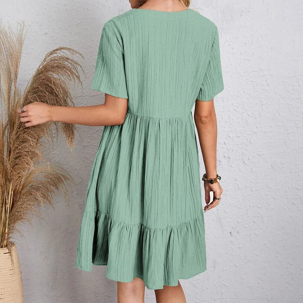 Person wearing a green dress against a neutral background