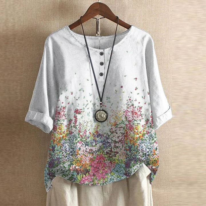 White shirt with floral pattern on a hanger against a beige background