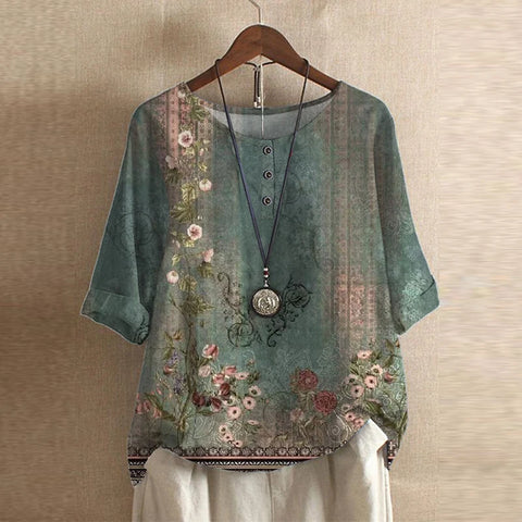 Floral embroidered blouse on a hanger against a beige wall