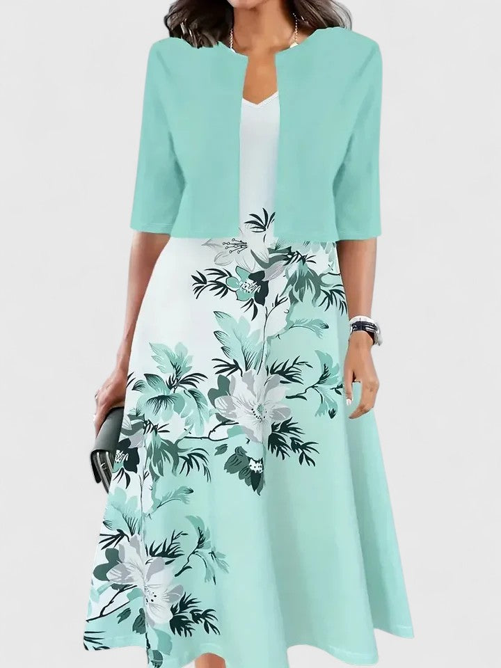 Woman wearing a light blue floral dress with a matching jacket on a white background