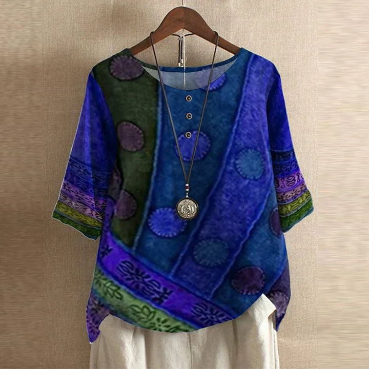 Colorful patterned top on a hanger against a beige wall