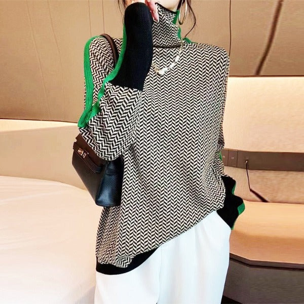Person wearing a black and white patterned top with green accents, holding a black handbag.