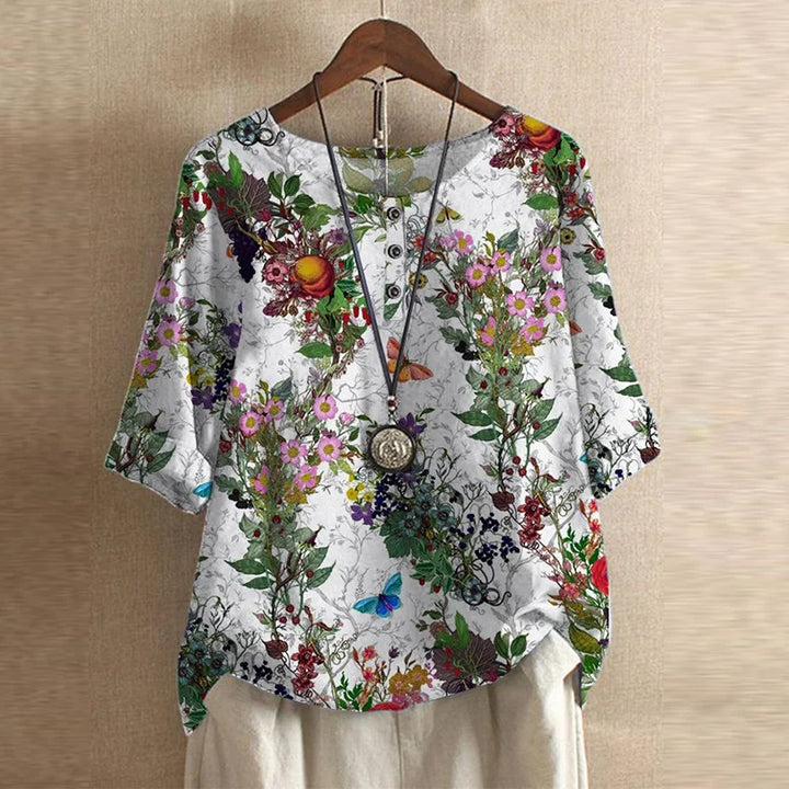 Floral patterned blouse on a hanger against a beige background