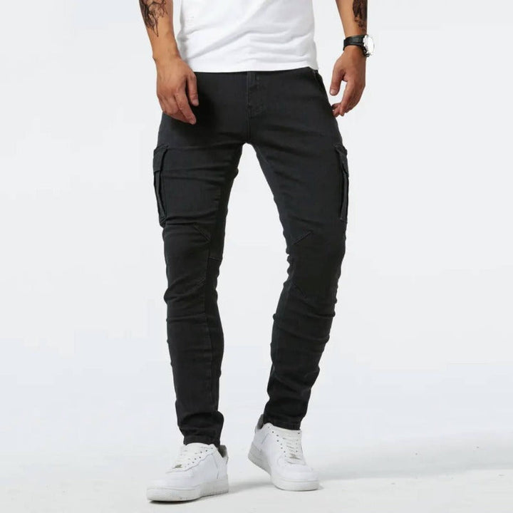 Person wearing black cargo pants and white sneakers on a white background