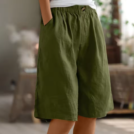 Person wearing green shorts in a blurred indoor setting