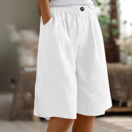 White shorts worn by a person in an indoor setting with blurred background