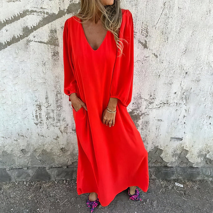 Person wearing a red dress standing against a textured wall.