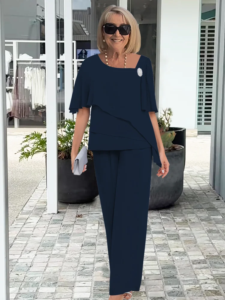 Woman in a navy blue outfit standing outdoors on a patio.