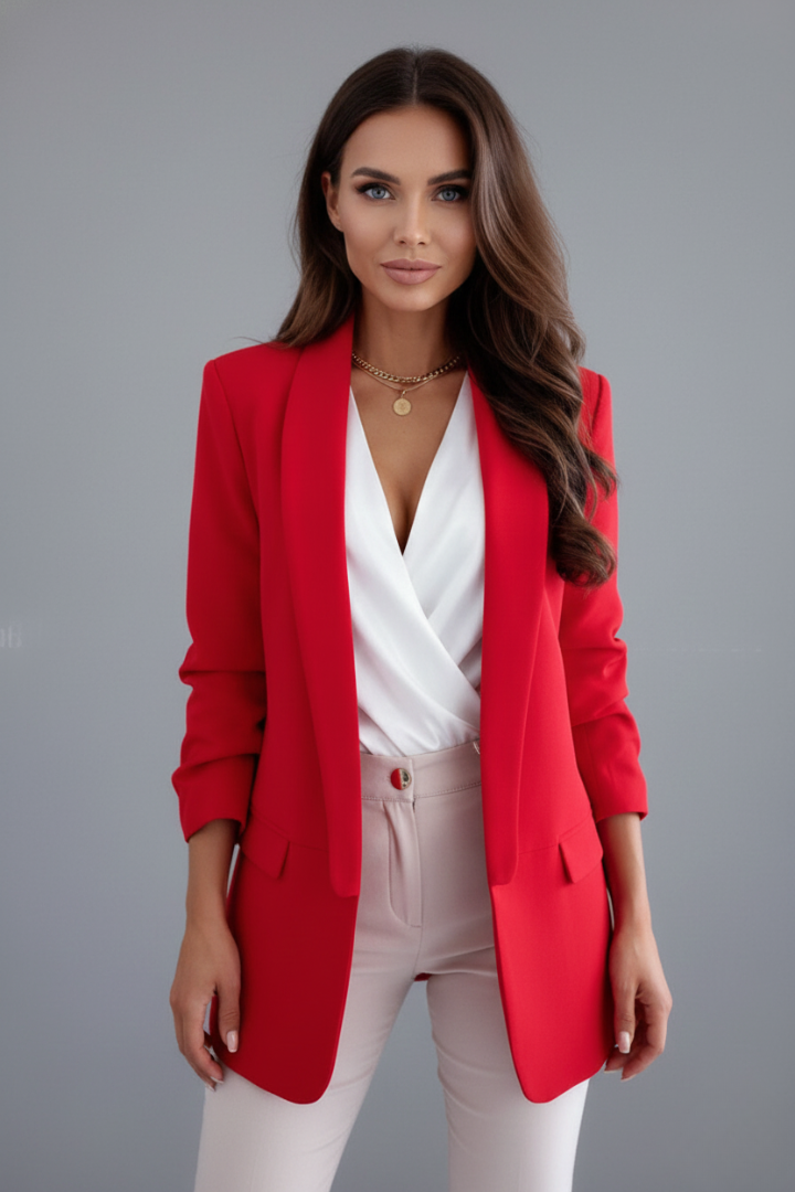Woman wearing a red blazer over a white top and pants on a gray background