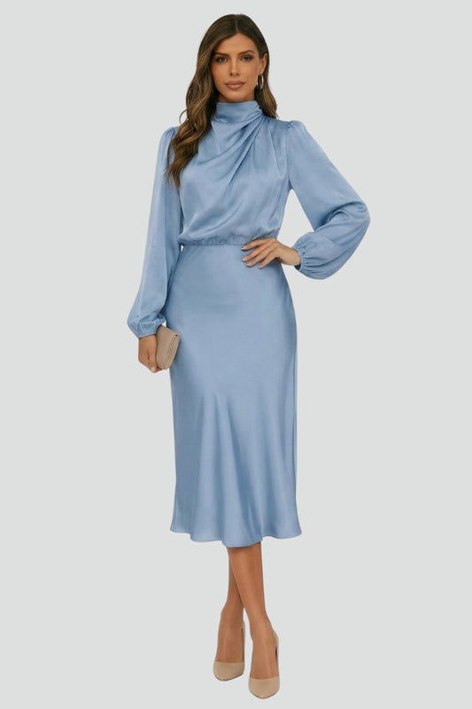 Woman wearing a light blue dress with long sleeves on a white background