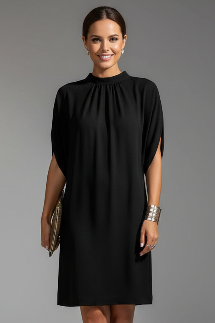 Woman wearing a black dress against a gray background