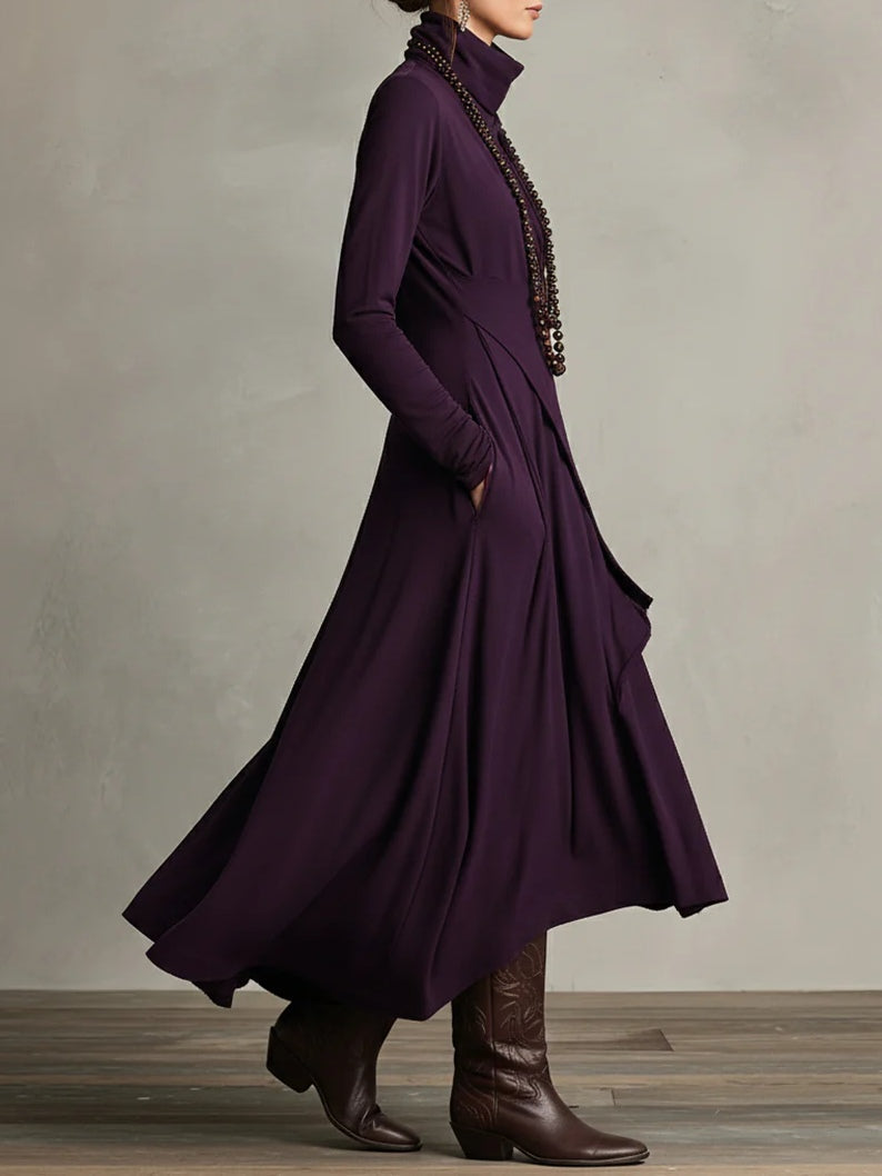 Long purple coat worn by a person against a neutral background