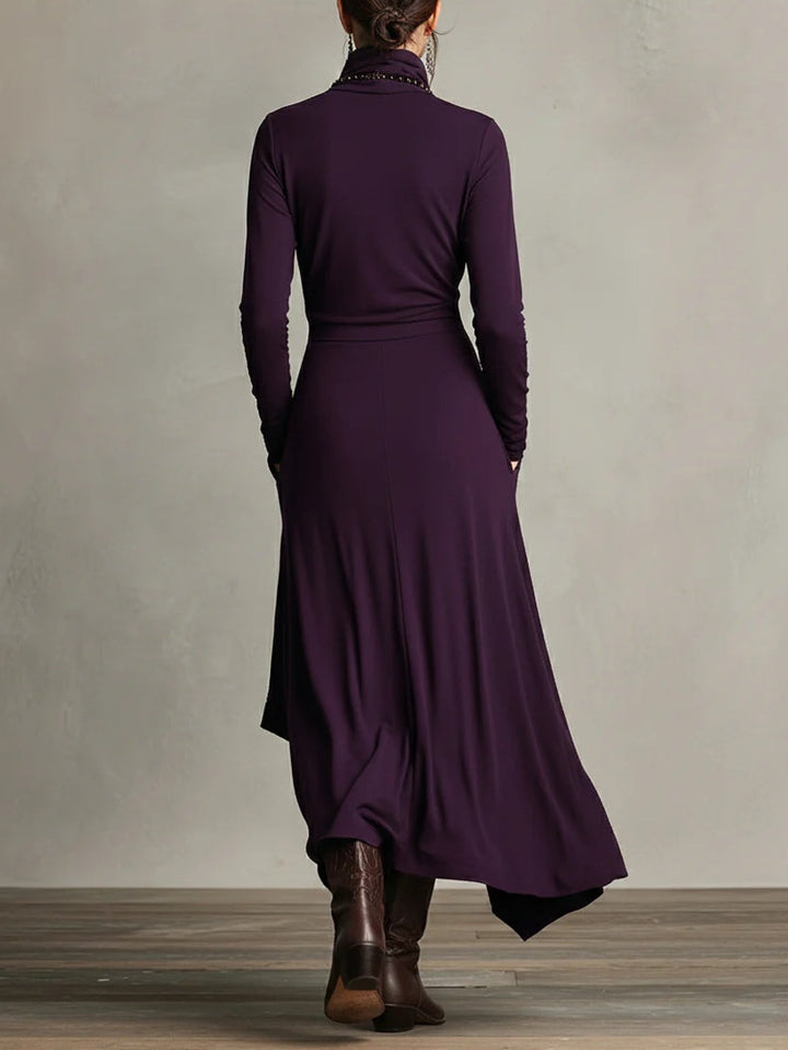 Purple dress worn by a person standing against a plain background