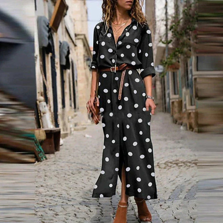 Woman wearing a black polka dot dress on a street.