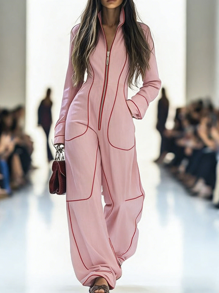 Model wearing a pink outfit with red accents on a runway.