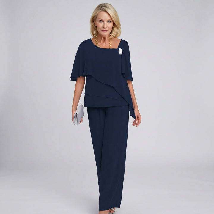 Woman wearing a navy blue outfit on a gray background