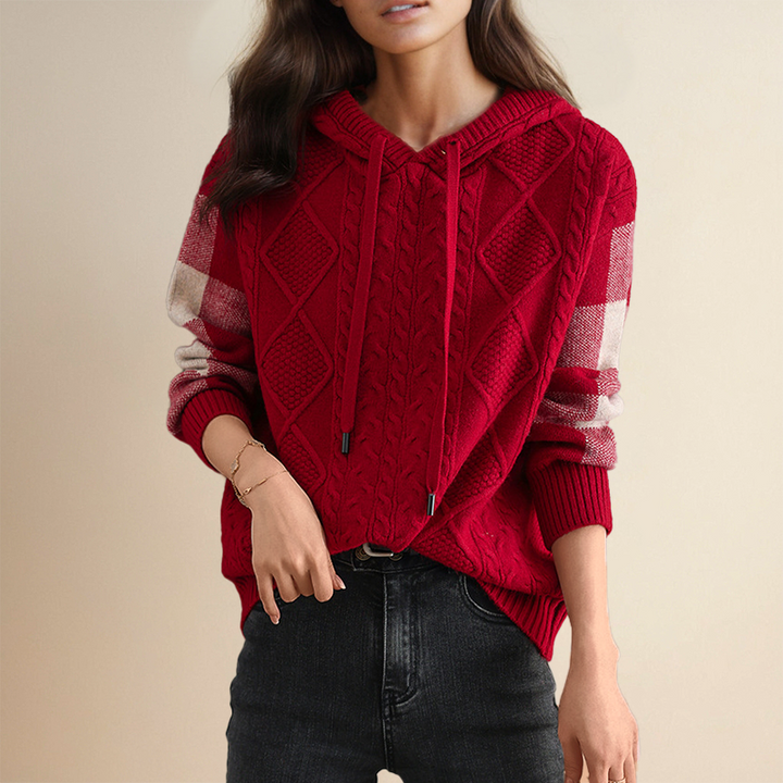 Red knitted cardigan with plaid sleeves worn by a person on a beige background